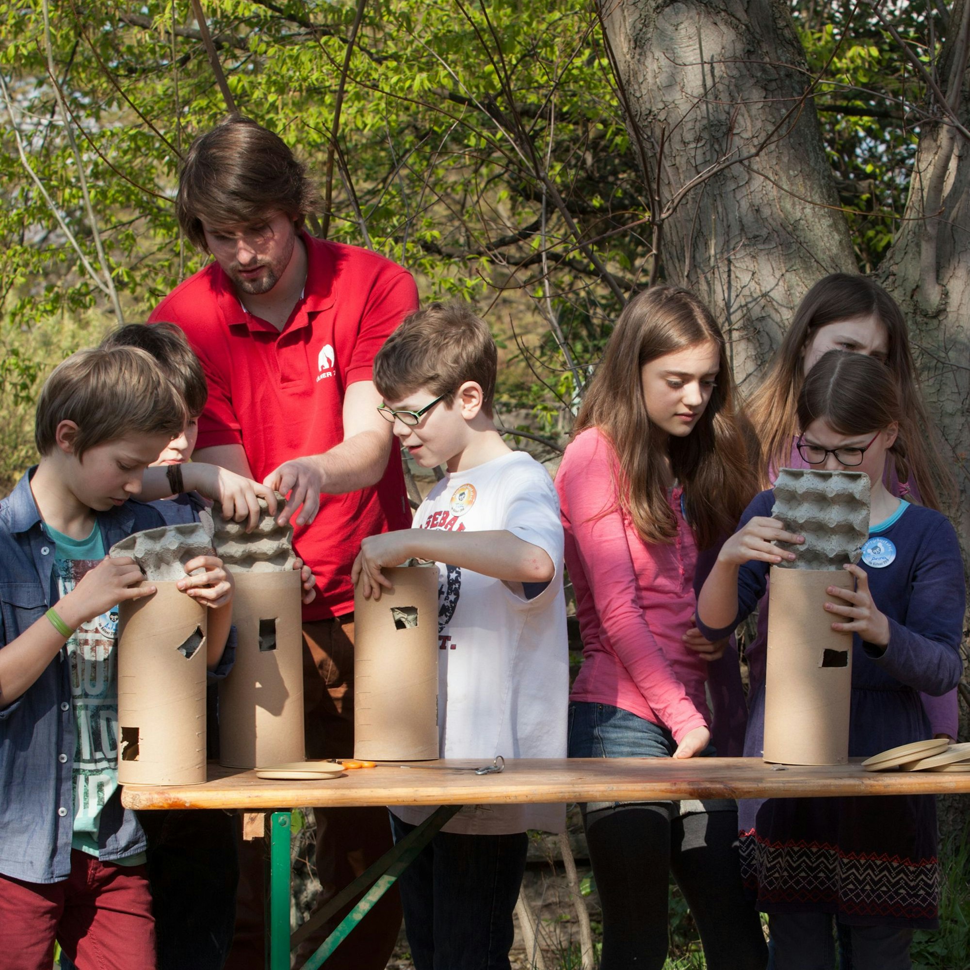 Kinder basteln Beschäftigungsröhren für Erdmännchen.