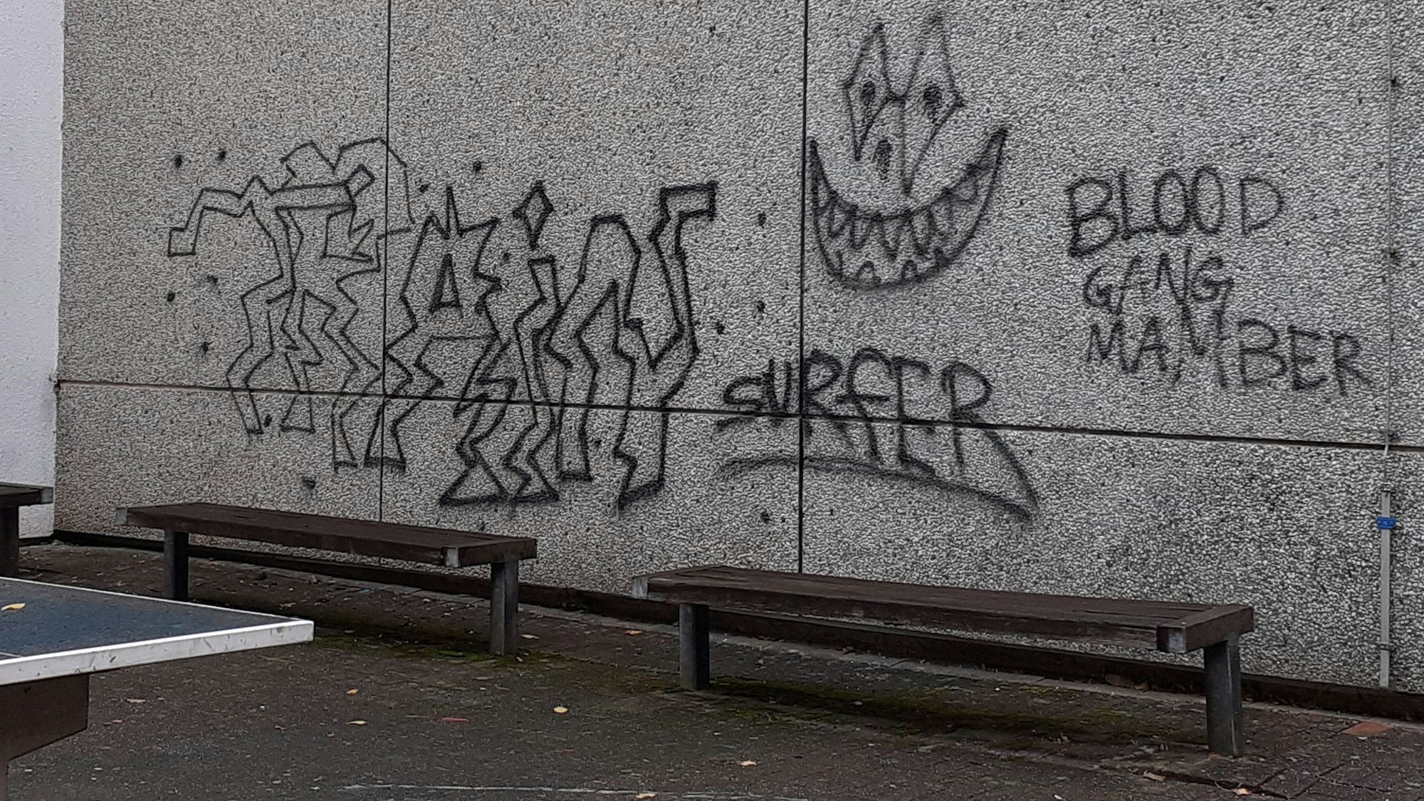 Ein Schulgebäude mit Farbschmierereien an der Fassade.