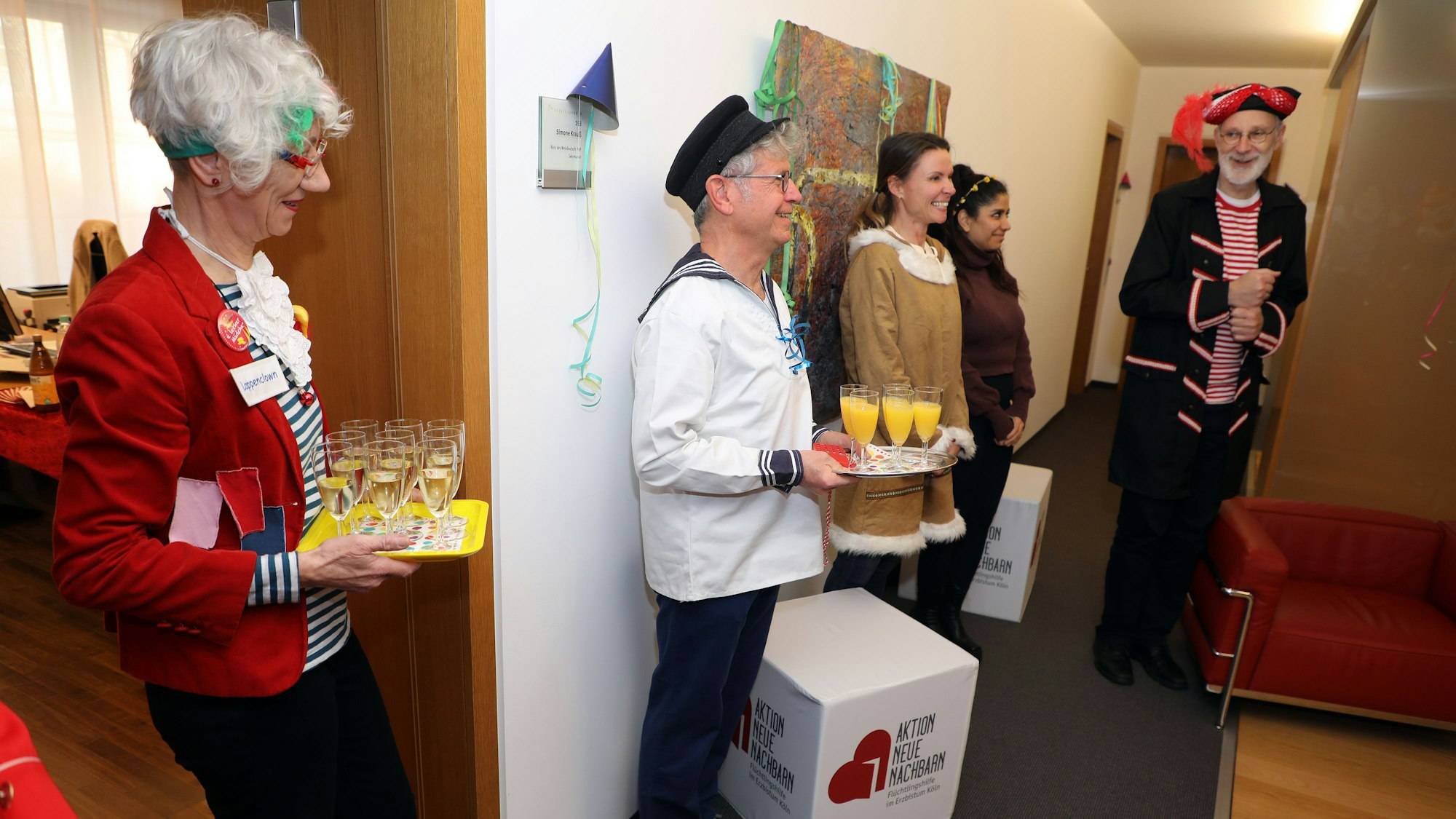 Weihbischof Ansgar Puff und sein Team stehen mit Getränken und bunt kostümiert zum Empfang der Gäste bereit.
