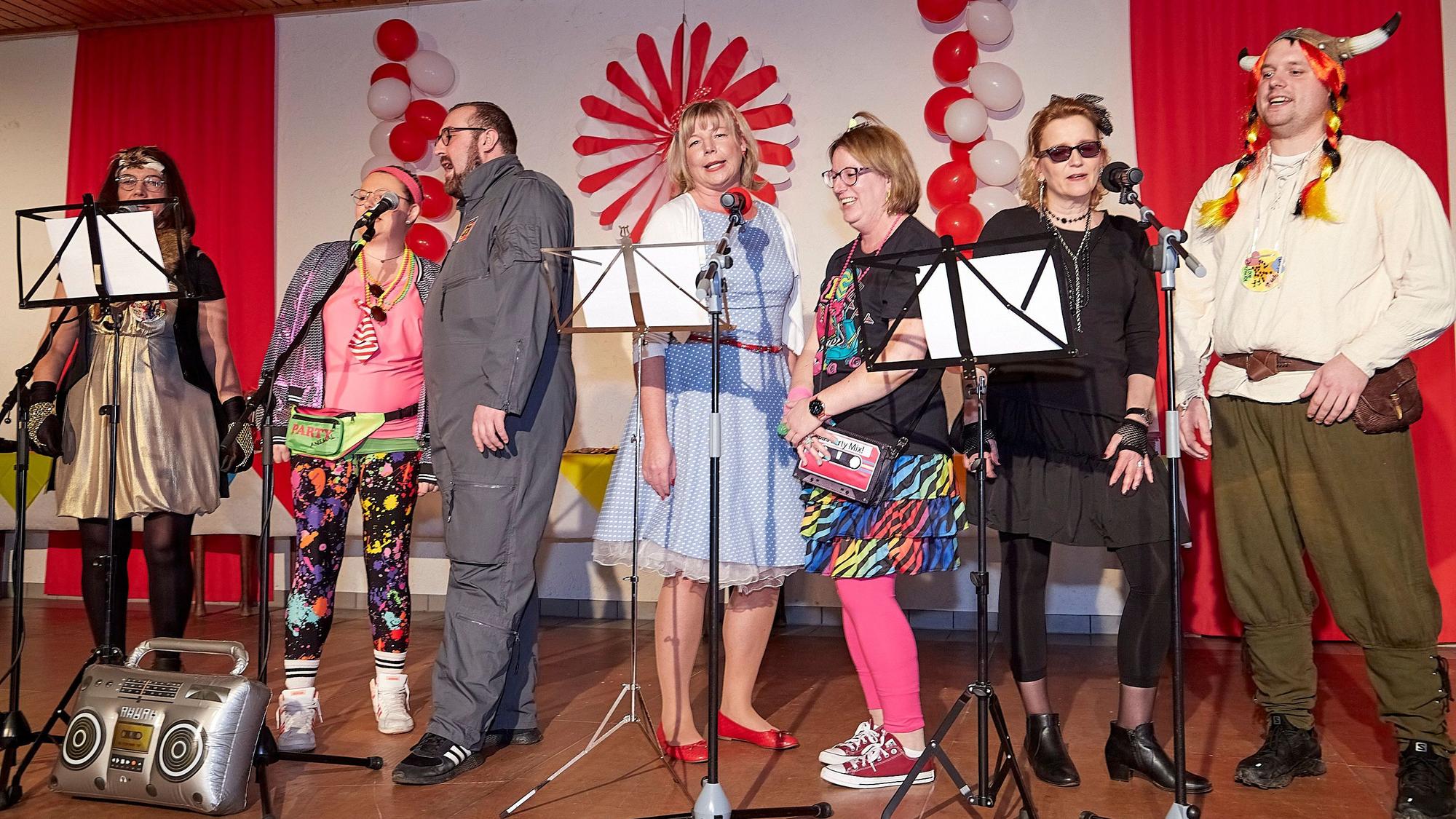 Karnevalisten stehen auf der Bühne und singen.