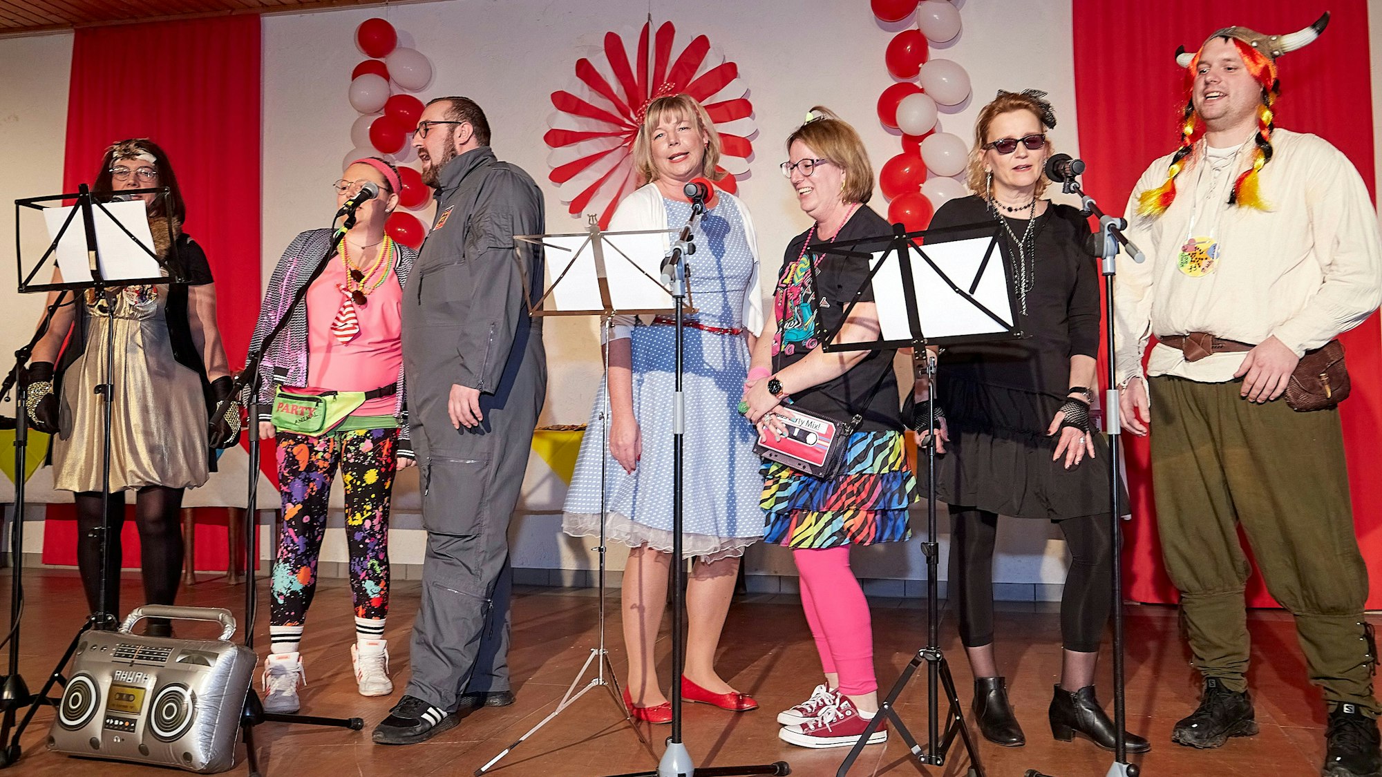 Karnevalisten stehen auf der Bühne und singen.