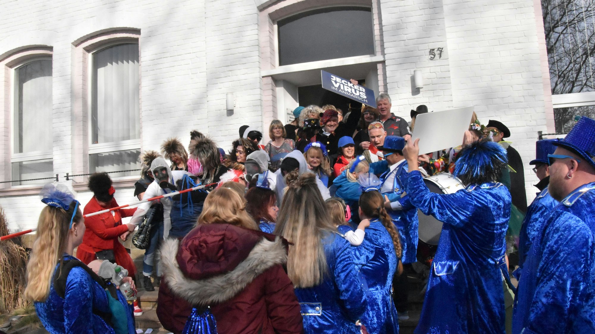 Menschen in Kostümen stehen vor dem Mucher Rathaus.