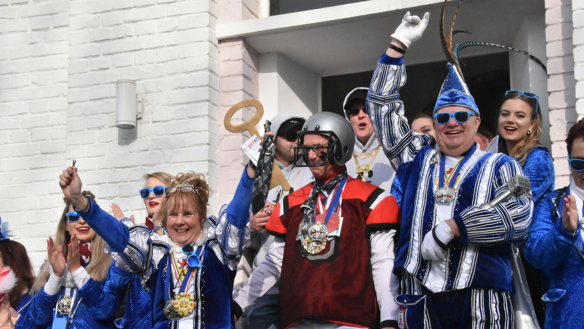 Mehrere Personen in Karnevalskostümen jubeln.