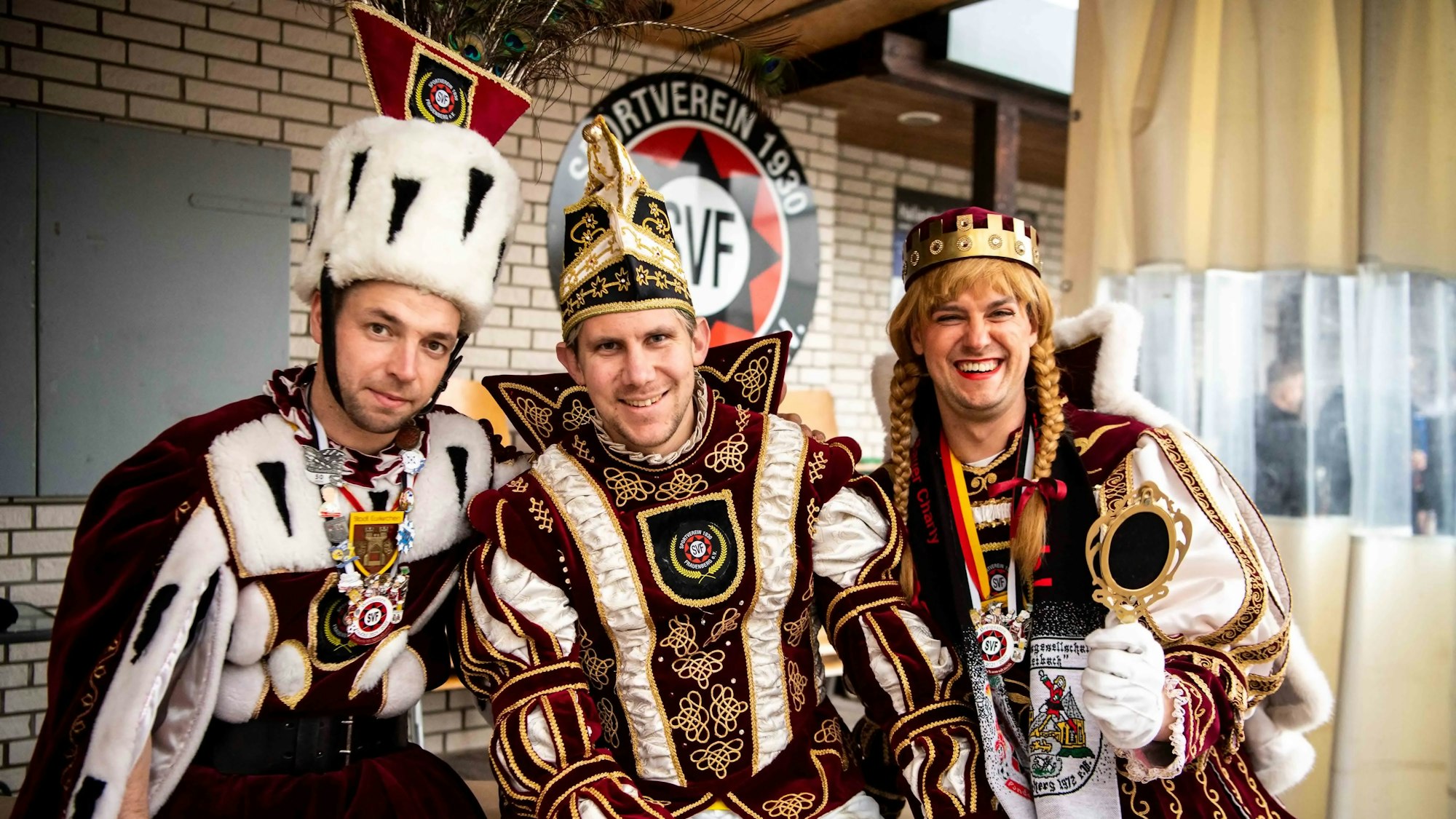 Das Frauenberger Dreigestirn posiert im Ornat vor dem Heim des Sportvereins.