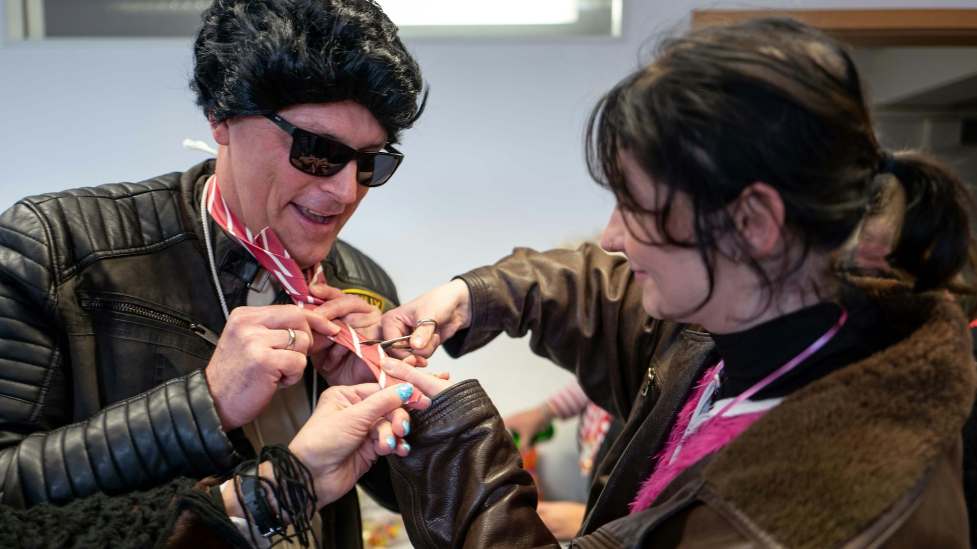 Volontärin "Et Elena" Pintus schneidet die Krawatte von Bürgermeister Ulf Hürtgen ab.