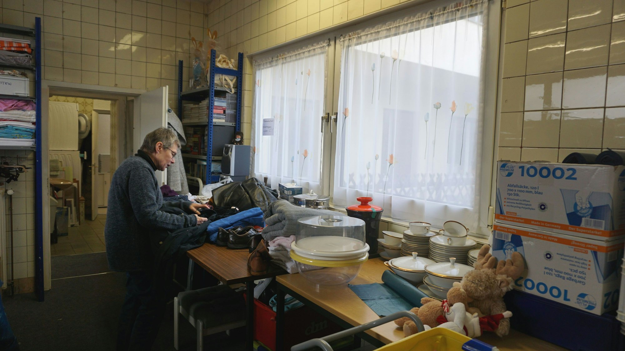 Hannelore Anders sortiert Kleidung.