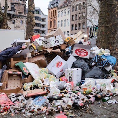 17.02.2023, Nordrhein-Westfalen, Köln: Zusammengefegter Müll aus der Weiberfastnacht liegt auf der Straße Mit der Weiberfastnacht hat der traditionelle Straßenkarneval begonnen. Foto: Oliver Berg/dpa +++ dpa-Bildfunk +++