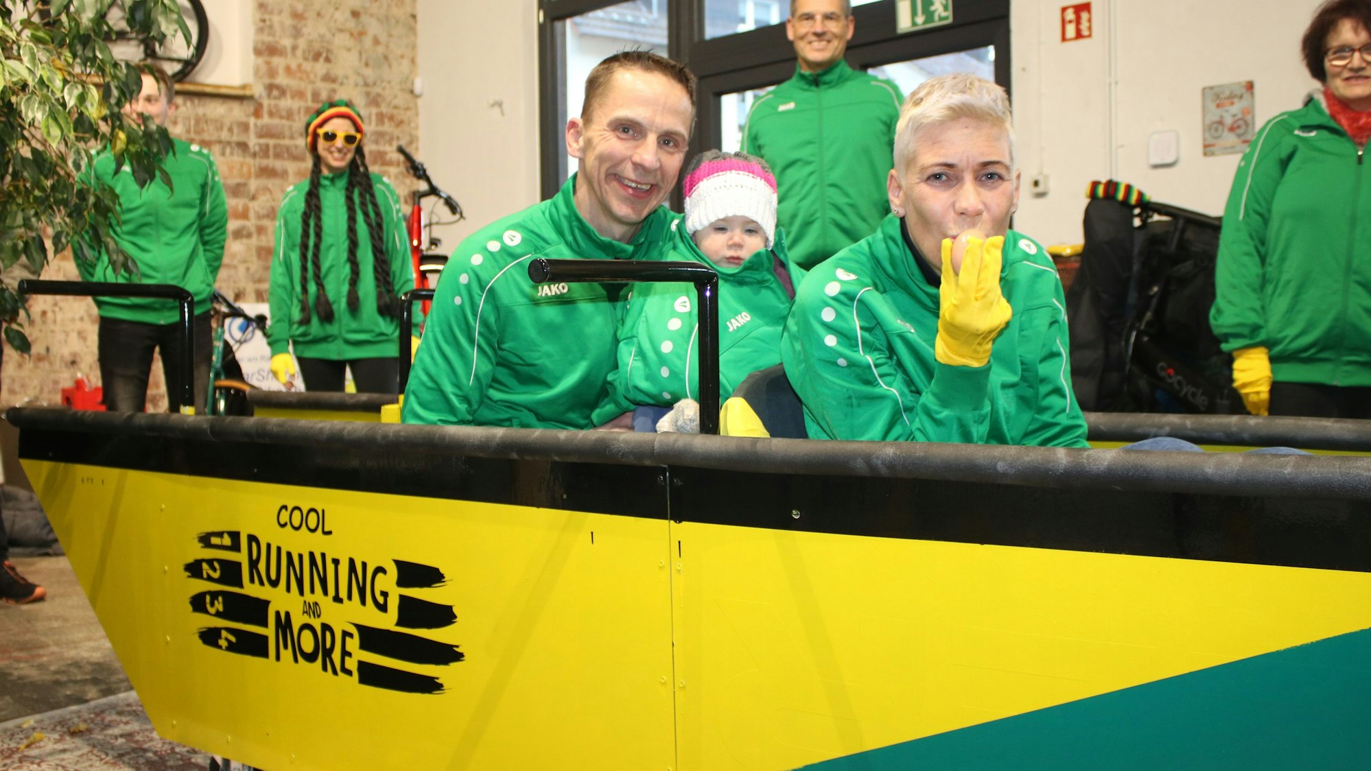 Zu sehen sind drei Menschen in einem bunt bemalten Bob.