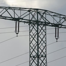 Ein Mann steht auf einem Strommast.