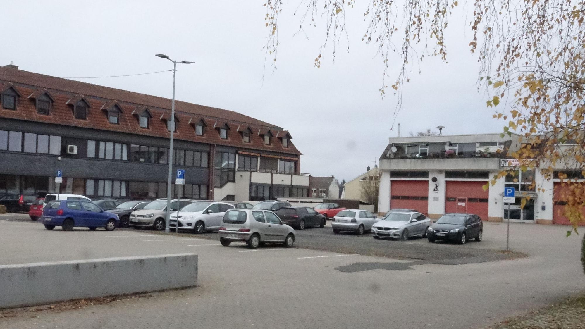 Blick auf den Parkplatz, das Rathaus und die Feuerwehrwache.