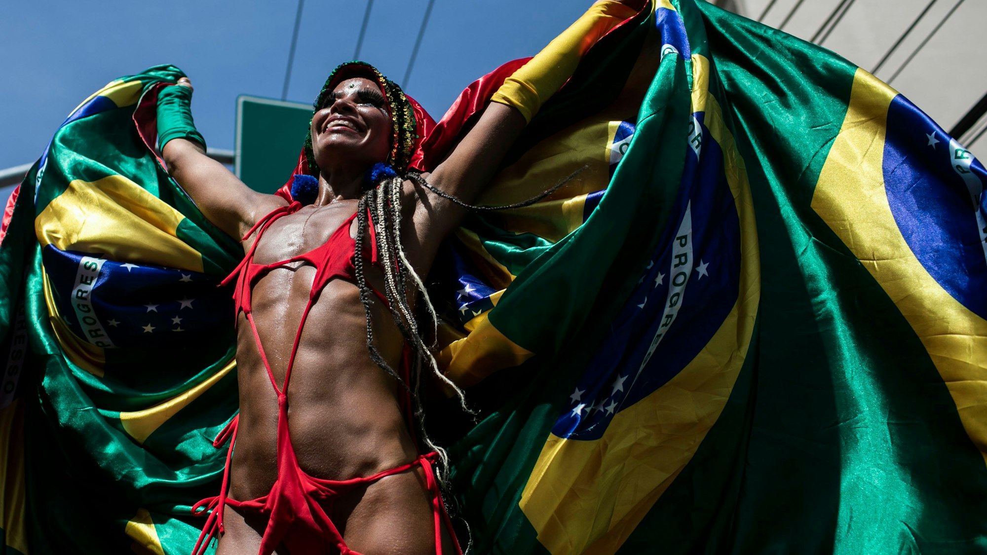 Ein Feiernder steht auf Stelzen umhüllt in einer brasilianischen Flagge während der Carmelitas-Straßenparty am ersten Tag des Karnevals in Rio De Janeiro.
