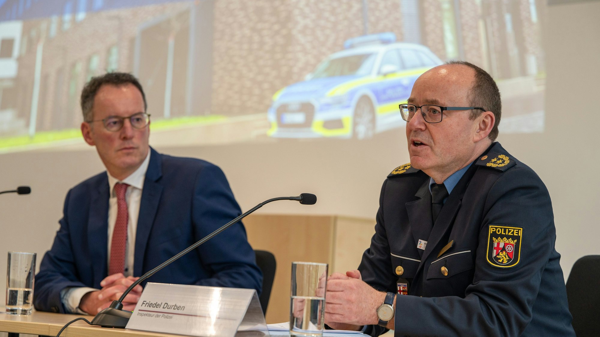 Der Inspekteur der rheinland-pfälzischen Polizei, Friedel Durben (r) spricht im Beisein des rheinland-pfälzischen Innenminister Michael Ebling (SPD) beim Besuch der Polizei in Trier zu den Vorfällen in der Nacht zum Freitag. Sie sitzen an einem Tisch, vor ihnen sind Mikrofone.
