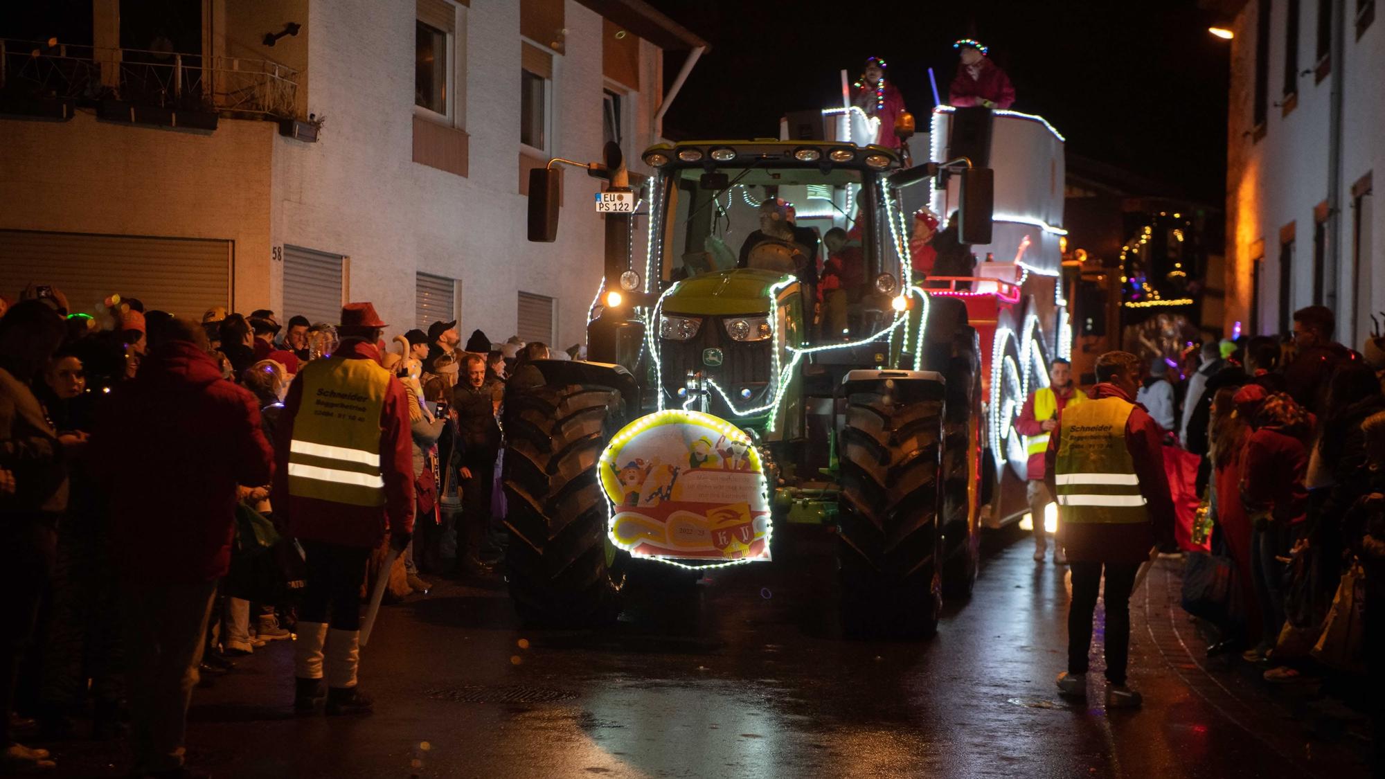 Das Bild zeigt den Lichterzug in Eiserfey. Ein Traktor samt Festwagen bahnt sich seinen Weg durch den Ort.