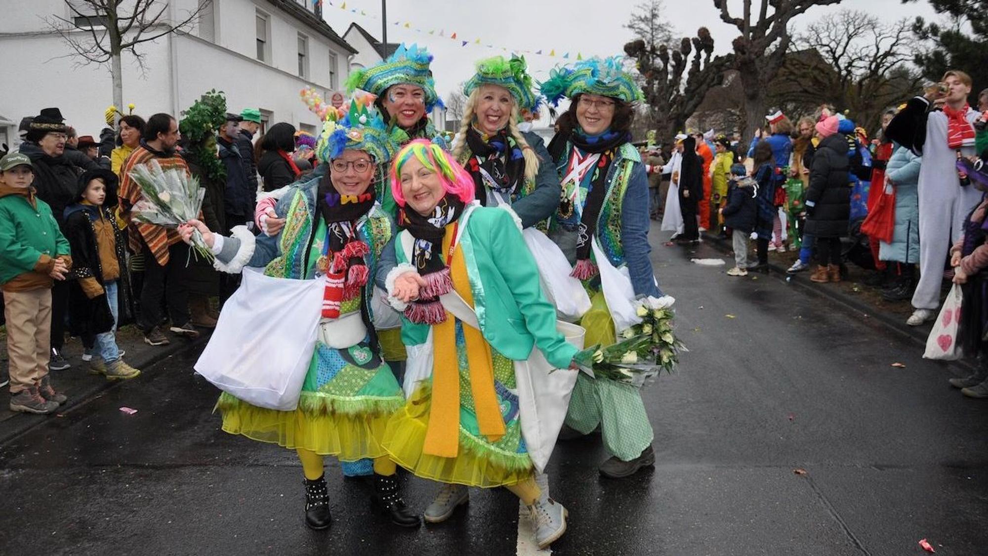 Mehrere Frauen stehen verkleidet auf einer Straße. Um sie herum sind weitere Menschen, die verkleidet sind.