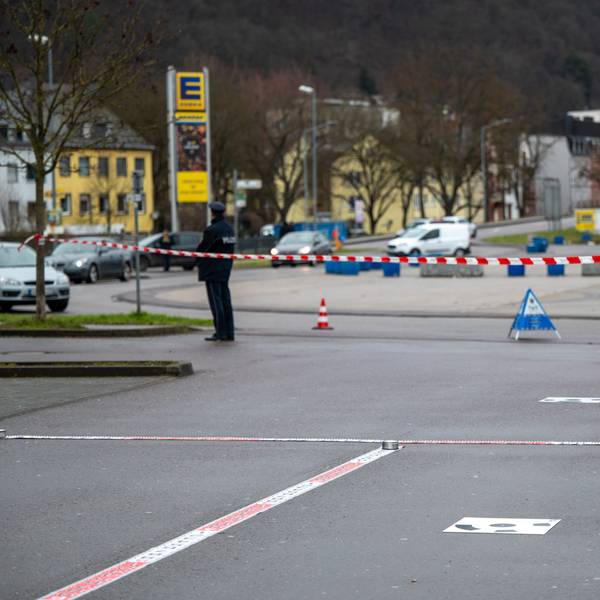 Polizisten haben einen Tatort vor einer Discothek abgesperrt. Im Hintergrund steht ein Polizist an einem Absperrband.
