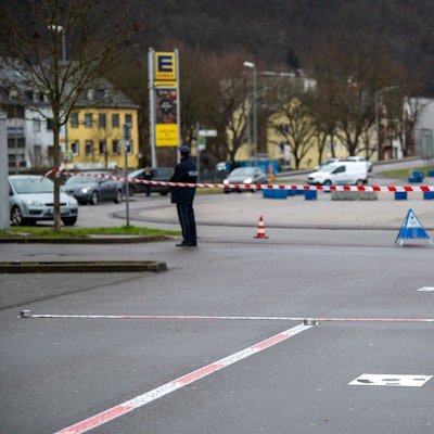 Polizisten haben einen Tatort vor einer Discothek abgesperrt. Im Hintergrund steht ein Polizist an einem Absperrband.