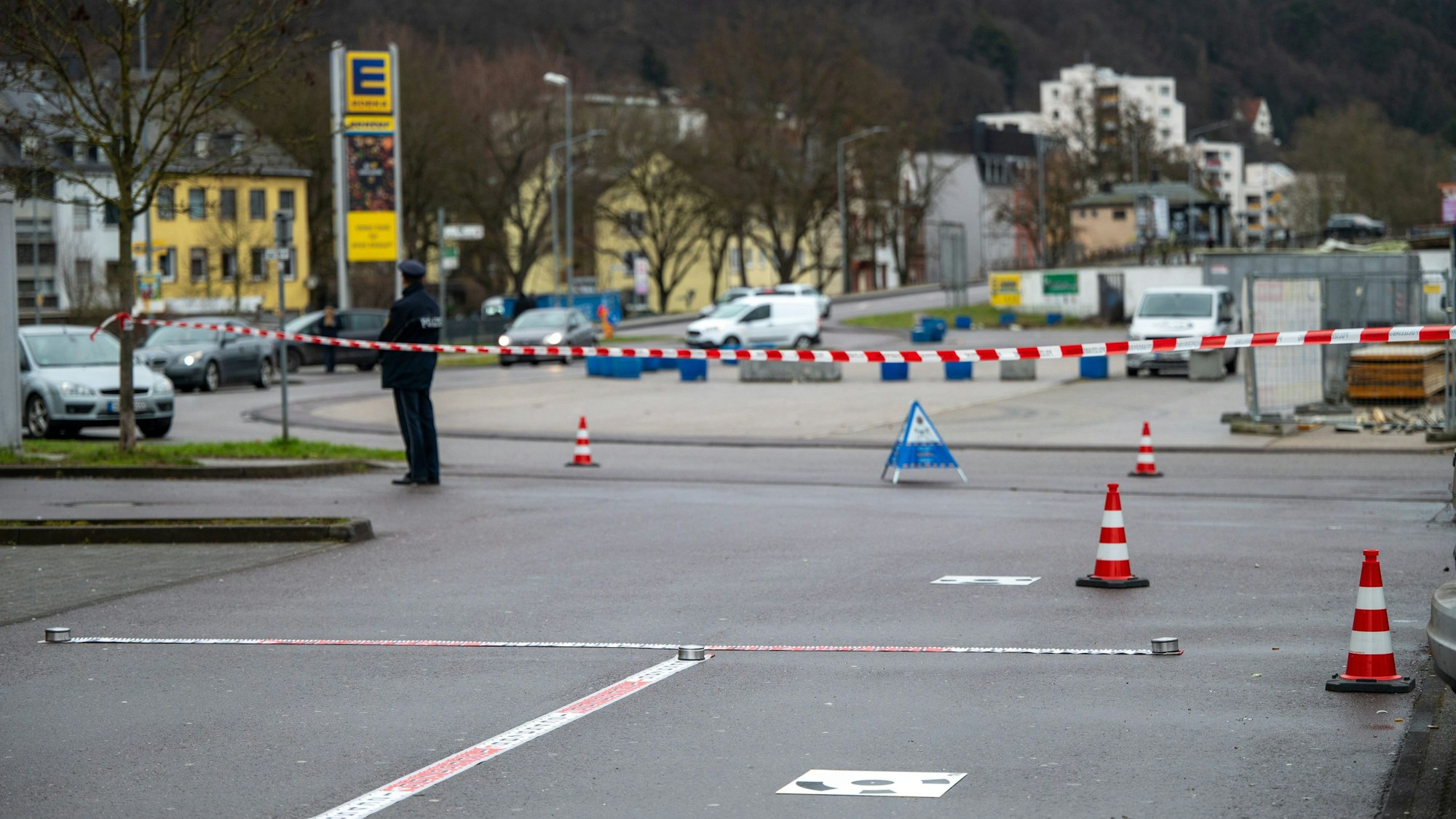 Polizisten haben einen Tatort vor einer Discothek abgesperrt. Im Hintergrund steht ein Polizist an einem Absperrband.