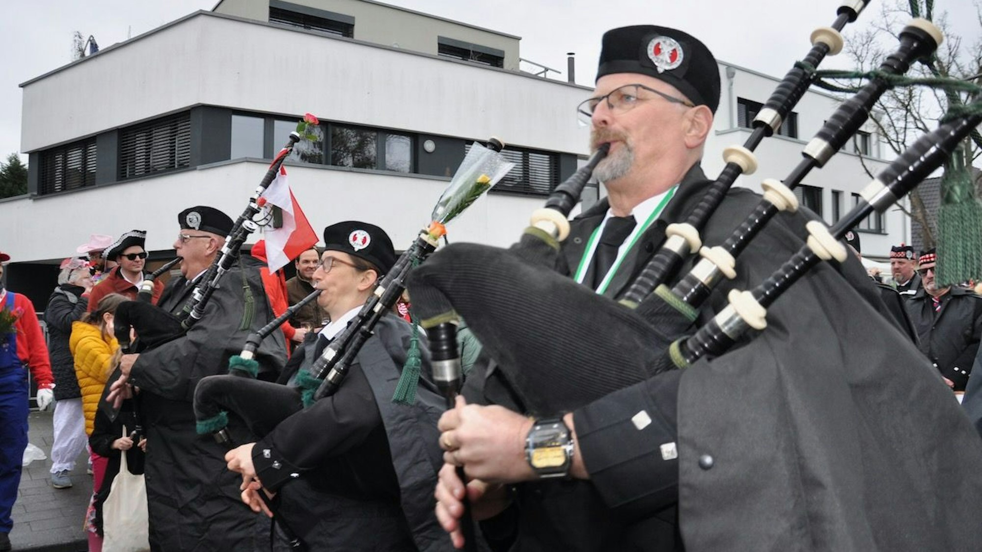 Ein Musiker spielt beim Zug durch Weiß auf einem Dudelsack.