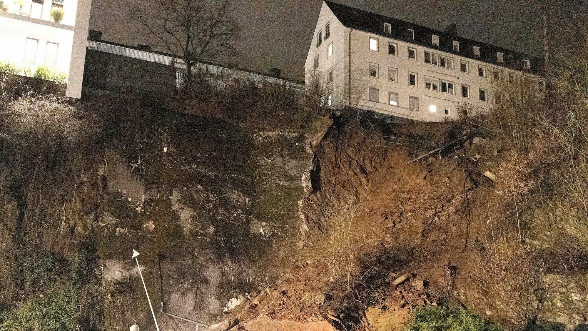 18.02.2023, Nordrhein-Westfalen, Siegen: Nah bei einem Wohnhaus ist ein Stück abgerutschten Hanges zu sehen.