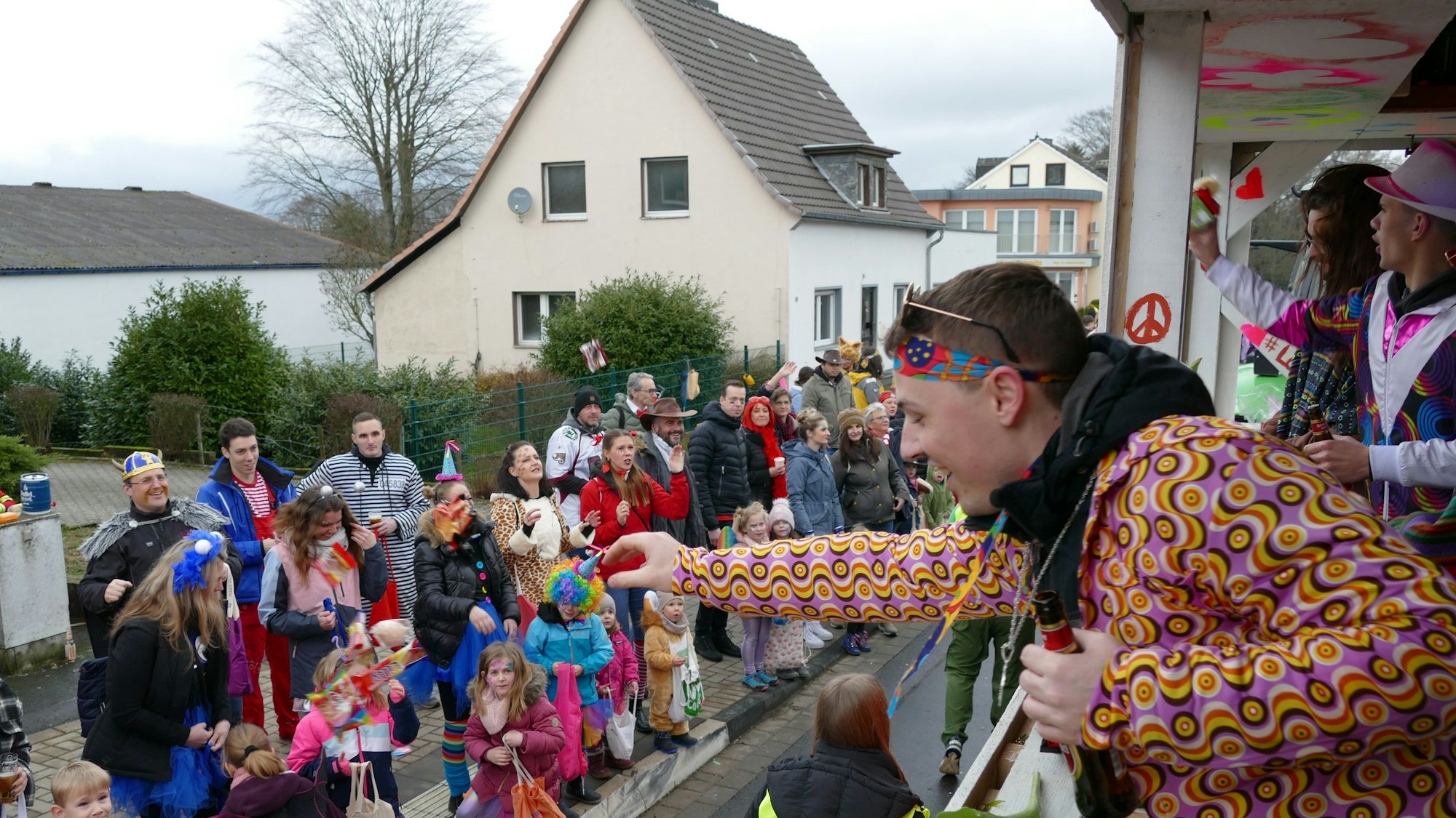 Ein Karnevalist wirft beim Karnevalszug in Birk Kamelle in die Menge.