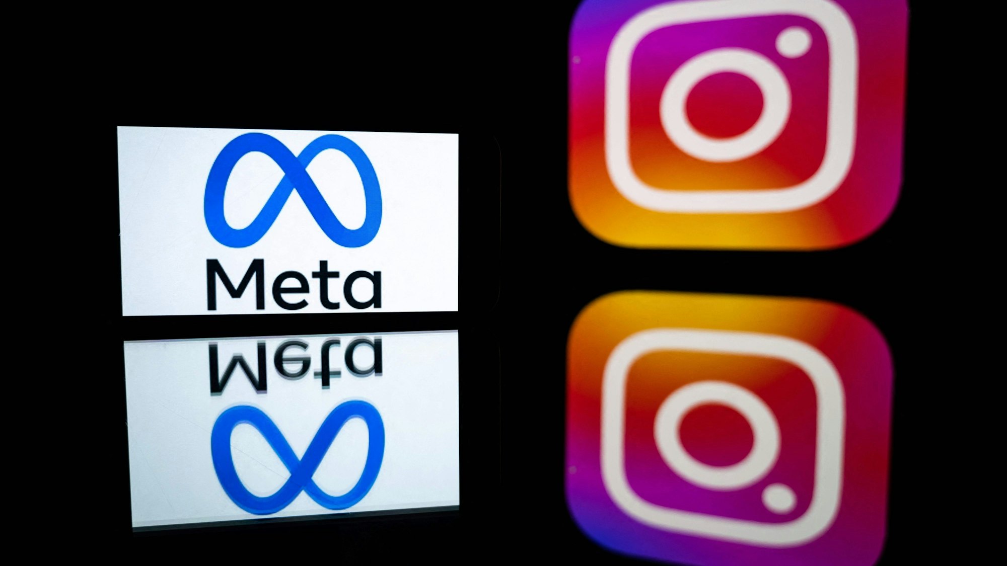 Diese Datei-Illustration zeigt ein Smartphone und einen Computerbildschirm mit den Logos der Instagram-App und des Mutterunternehmens Meta.