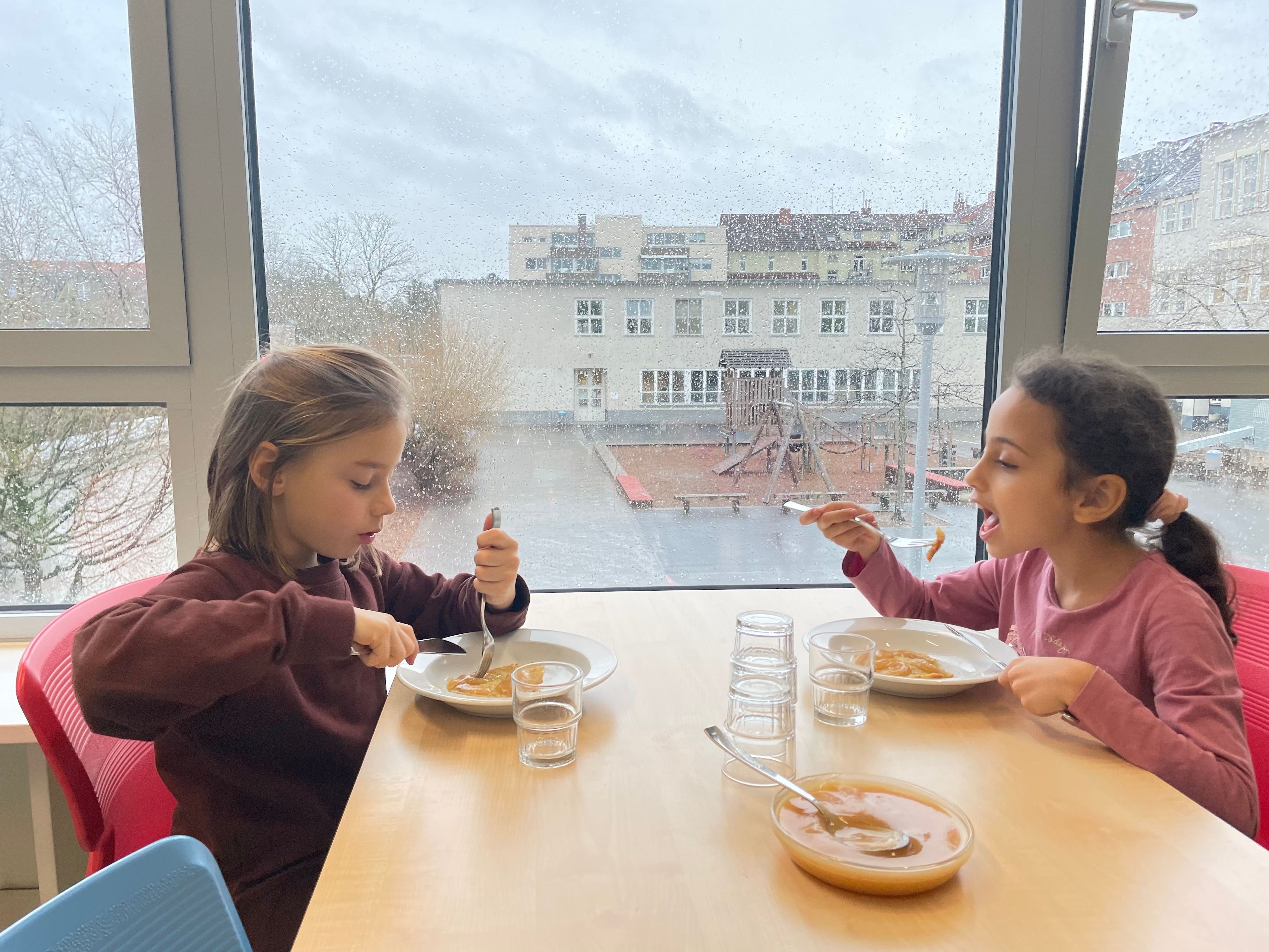 Lisa (l.) und Lina schmeckt Pfannkuchen mit Apfelmus.
