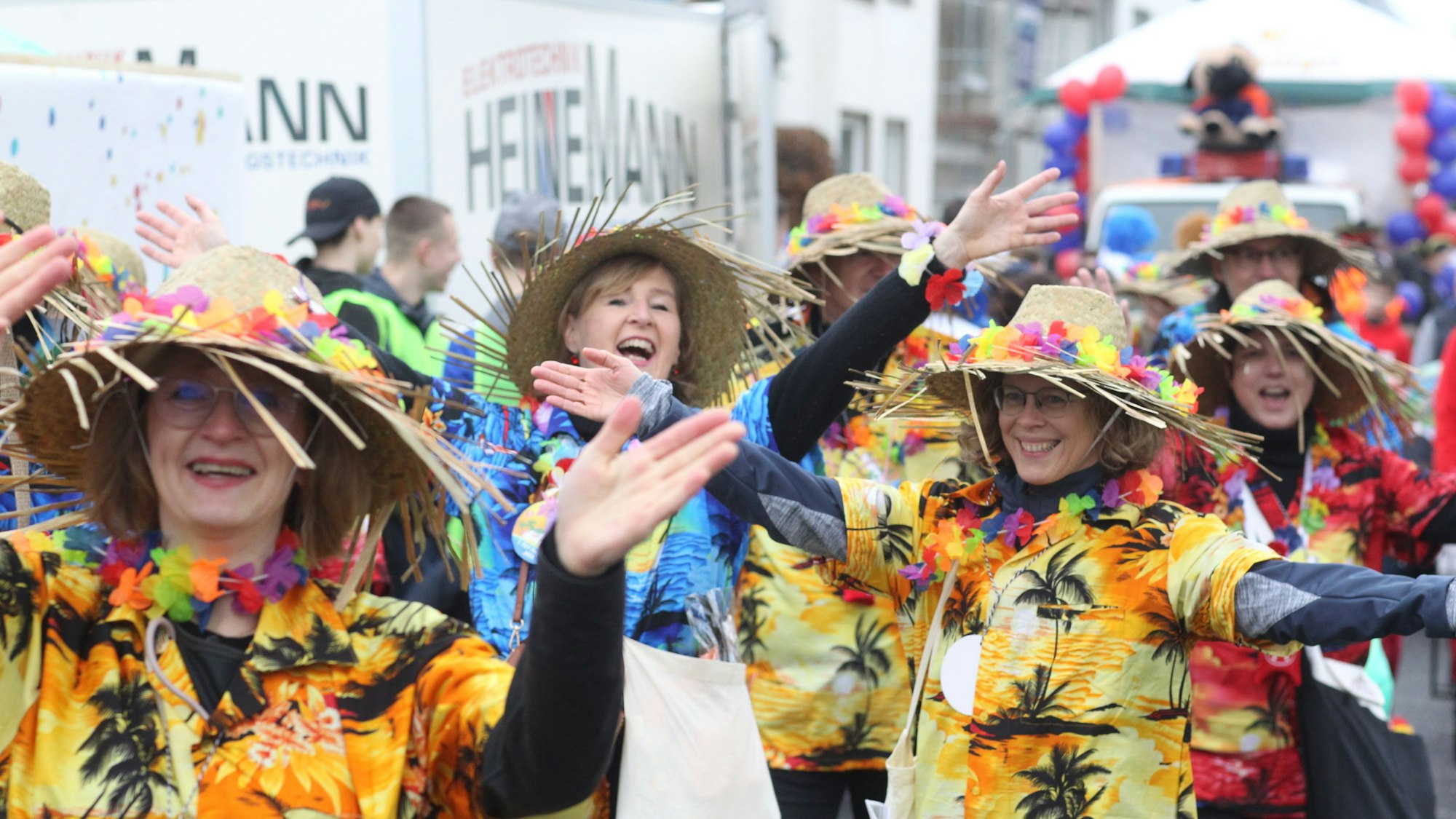 Eine Gruppe läuft bekleidet mit Hawaii-Hemden und Strohhüten in einem Karnevalszug mit.