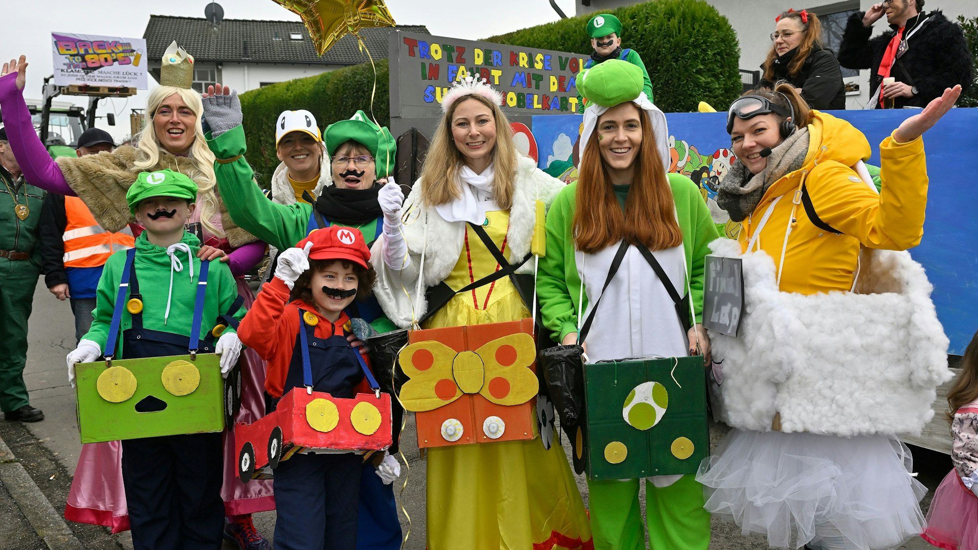 Verkleidete Jeken stehen auf dem Karnevalszug in Blecher.