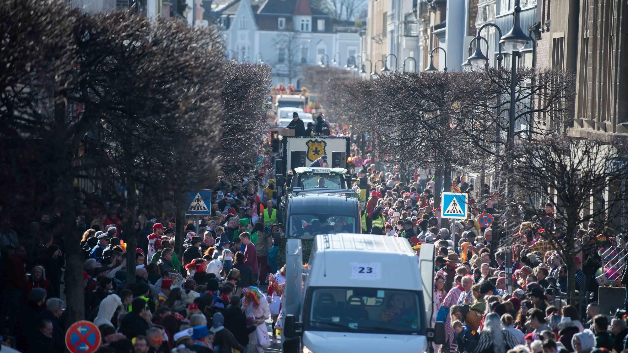 Wagen des Rosenmontagszugs in Euskirchen fahren durch die Wilhelmstraße. Links und rechts stehen zahlreiche Besucher.