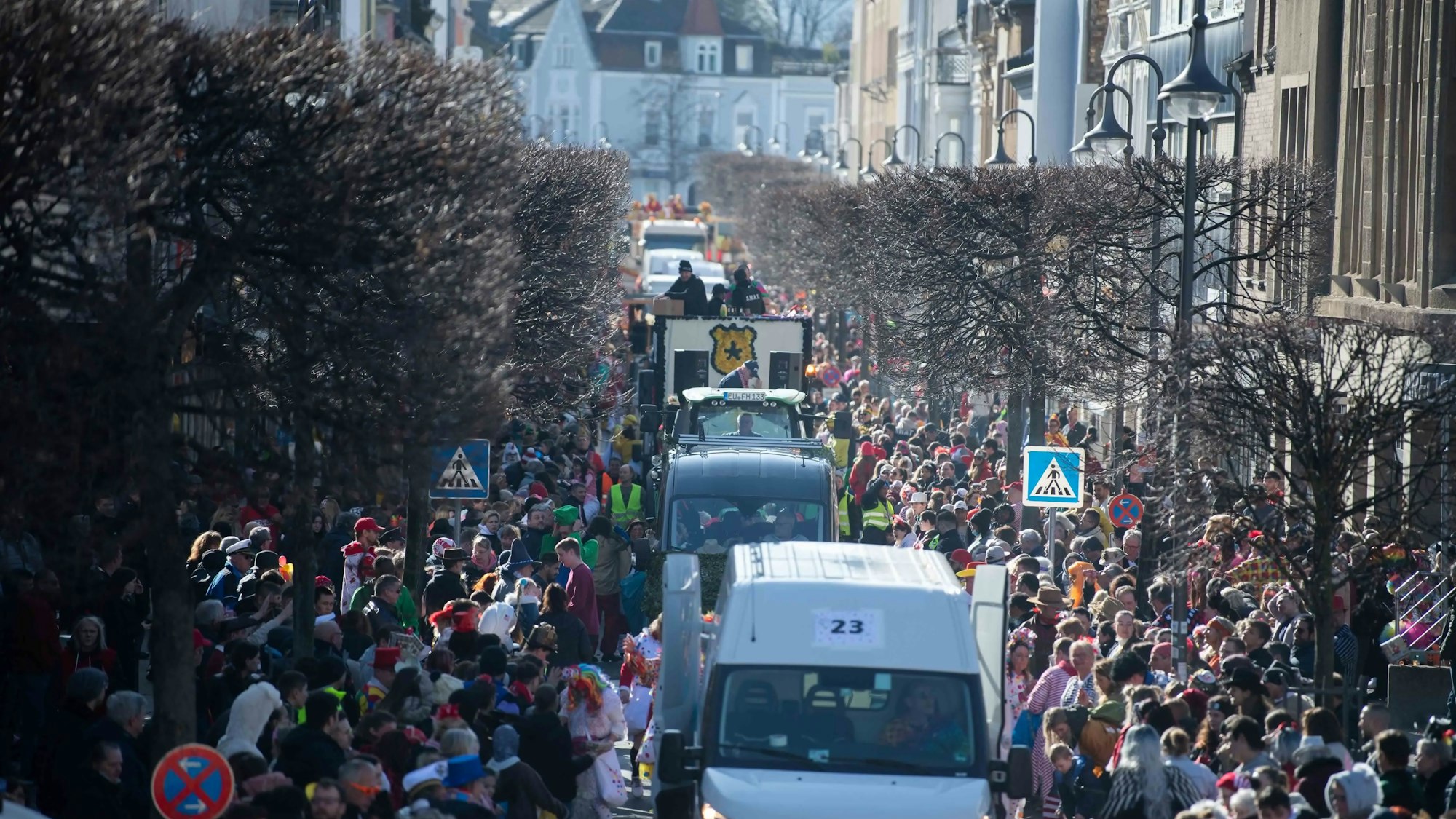 Wagen des Rosenmontagszugs in Euskirchen fahren durch die Wilhelmstraße. Links und rechts stehen zahlreiche Besucher.