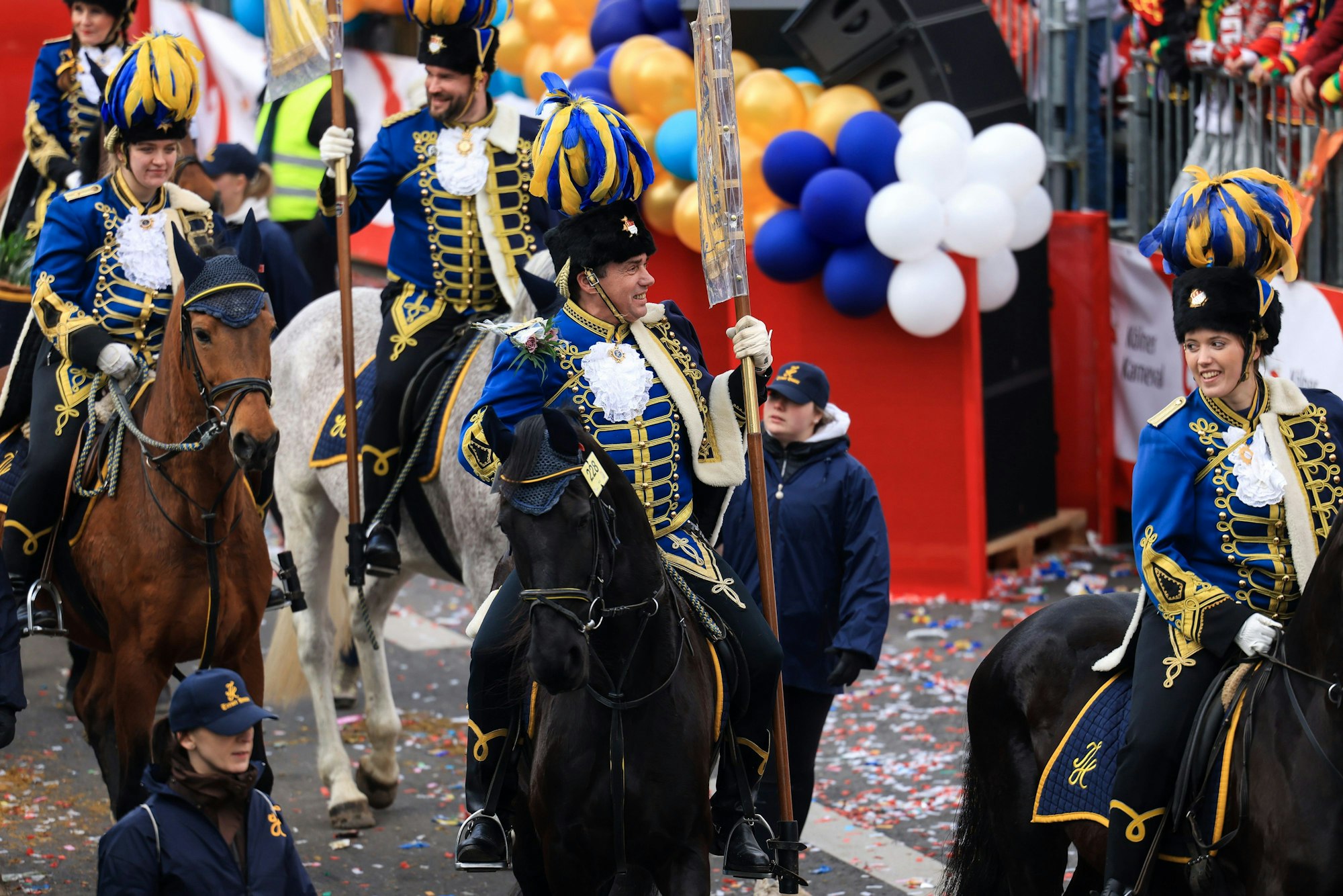 Reiter auf Pferden laufen im Festumzug mit.
