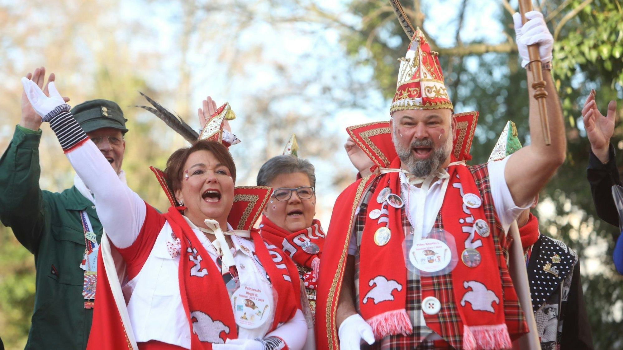 Ein in Rot und Weiß gekleidetes Paar ruft dreimal Alaaf!