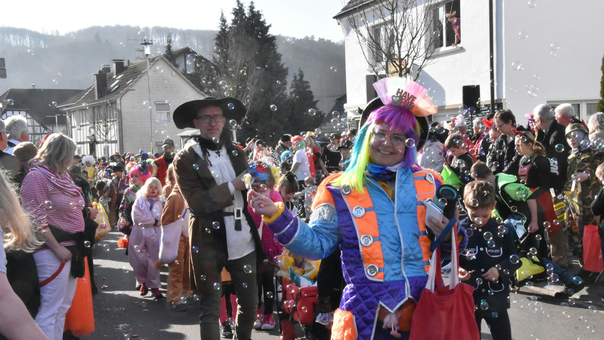 Verkleidete Kinder und Erwachsene laufen mit Seifenblasen beim Zug in Dattenfeld.