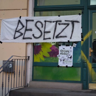 Es ist der Eingang zu seinem Büro der Grünen zu sehen, an dem ein Banner mit der Aufschrift ´Besetzt» hängt.