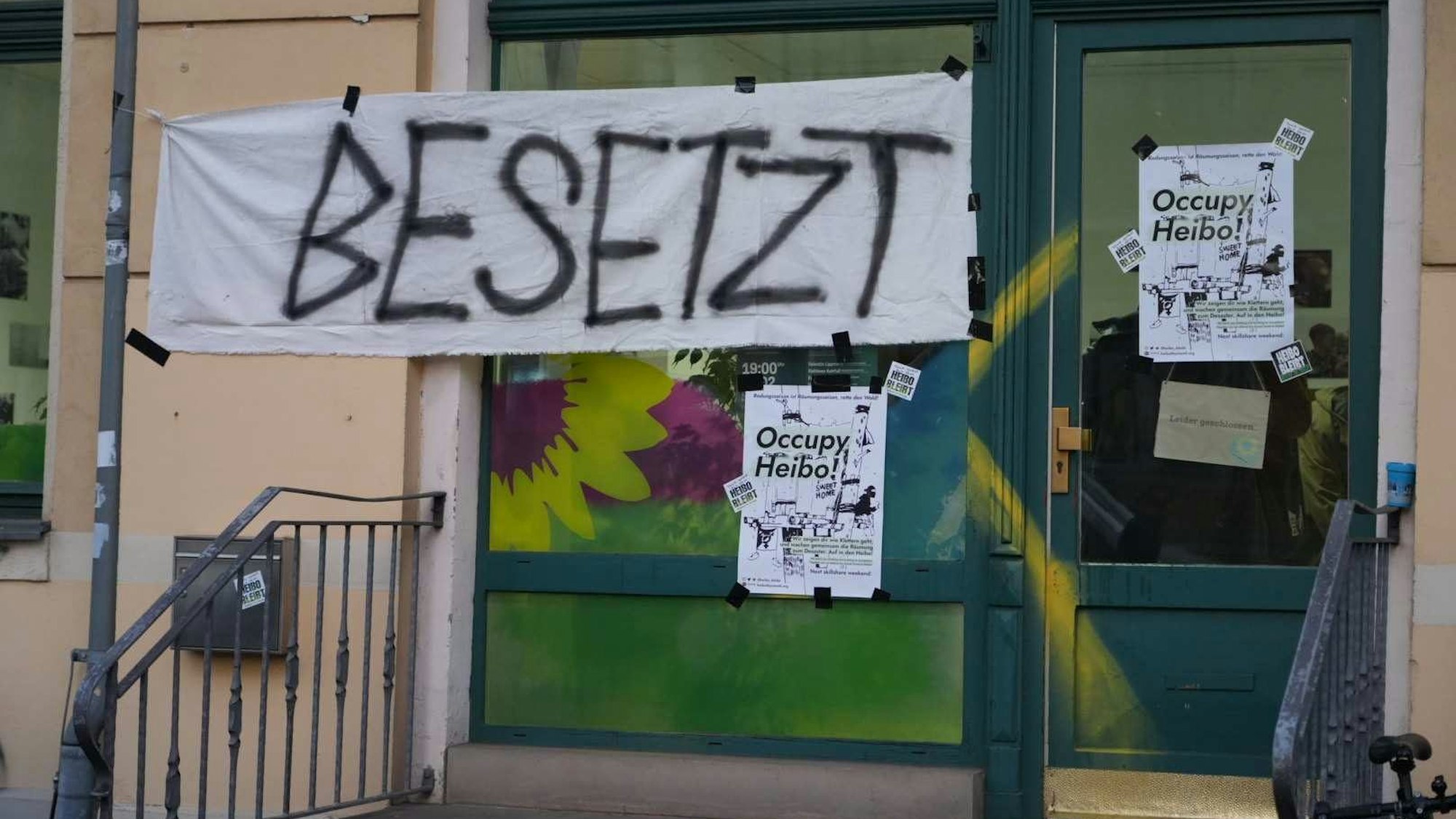 Es ist der Eingang zu seinem Büro der Grünen zu sehen, an dem ein Banner mit der Aufschrift ´Besetzt» hängt.