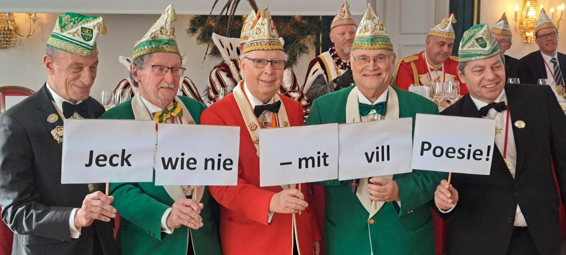 Die Karnevalisten halten das Motto mit Schildern hoch.