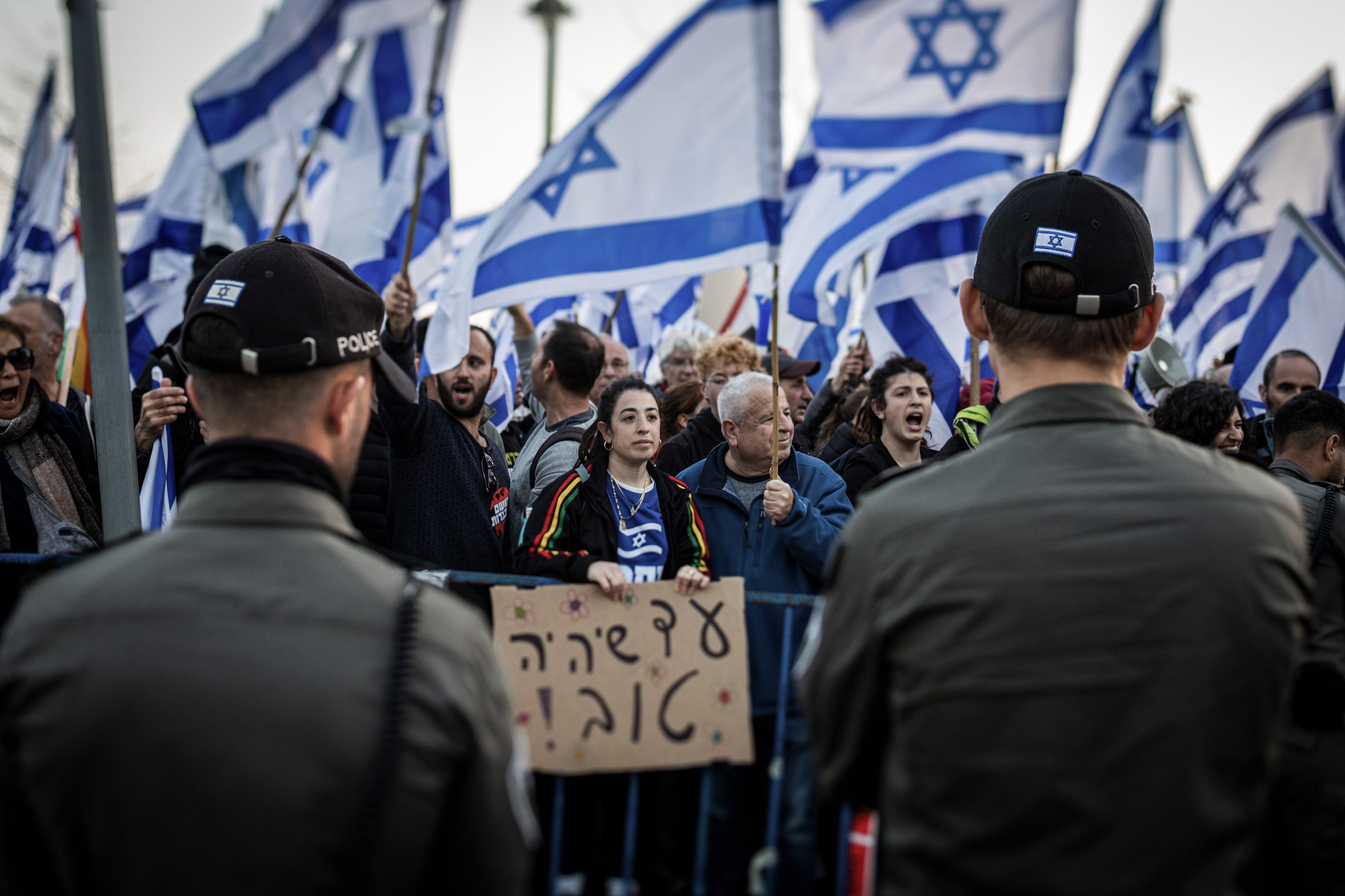 20.02.2023, Israel, Jerusalem: Demonstranten tragen israelische Fahnen während eines Protests