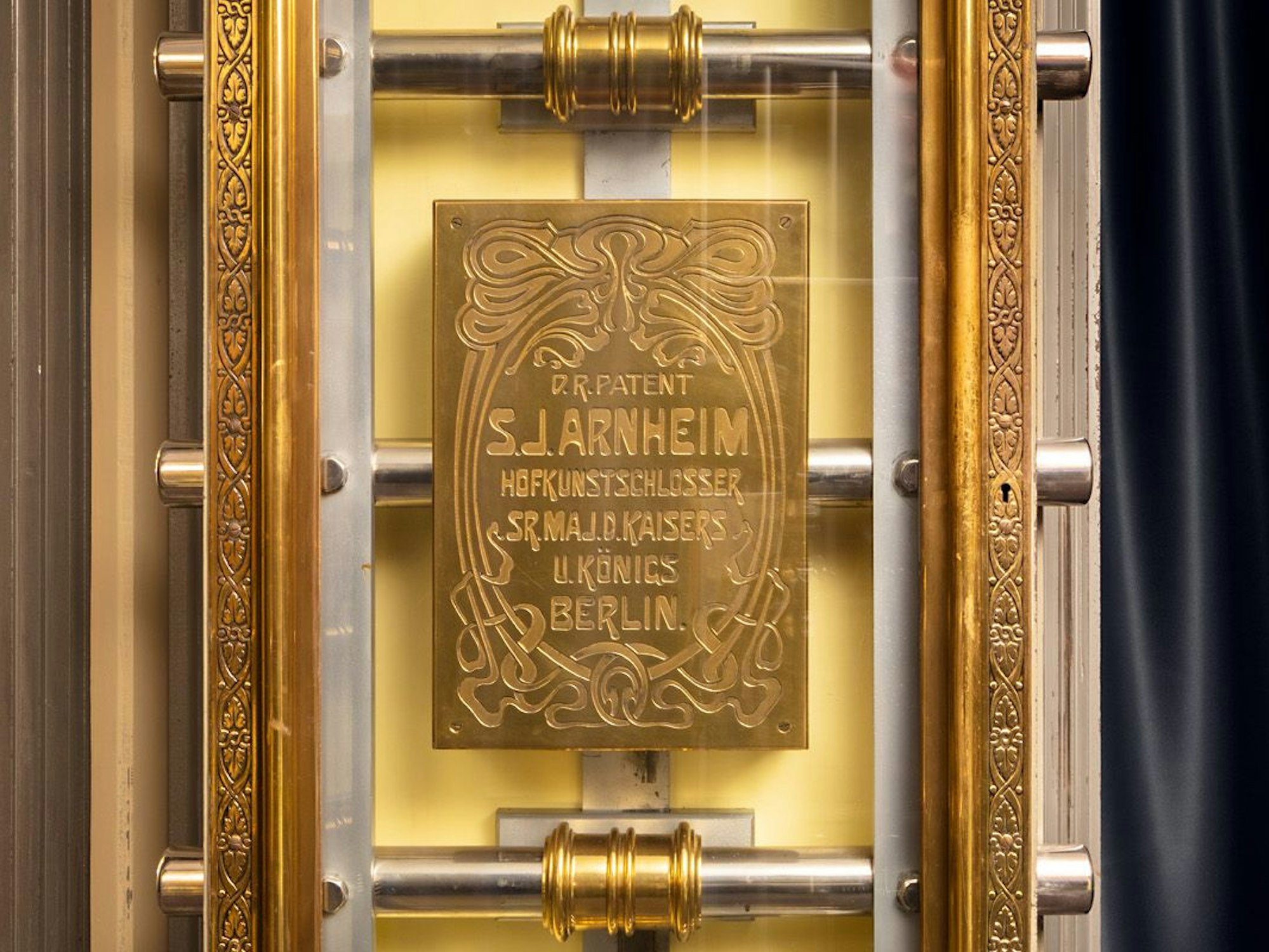 Eine vergoldete Platte steckt hinter Glas in der Tresortür der früheren Privatbank. Darauf hat sich der frühere Hofkunstschlosser des deutschen Kaisers mit seinem Patent verewigt: Simon J. Arnheim.
