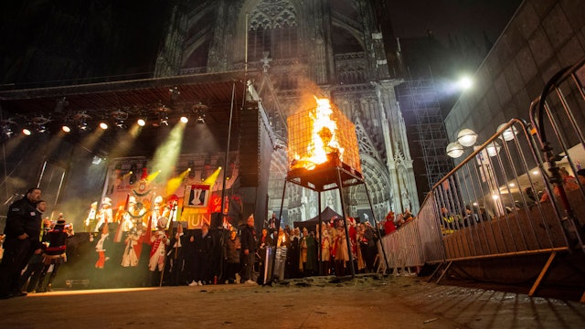 Vor dem angestrahlten Dom brennt der Nubbel in einem Käfig.