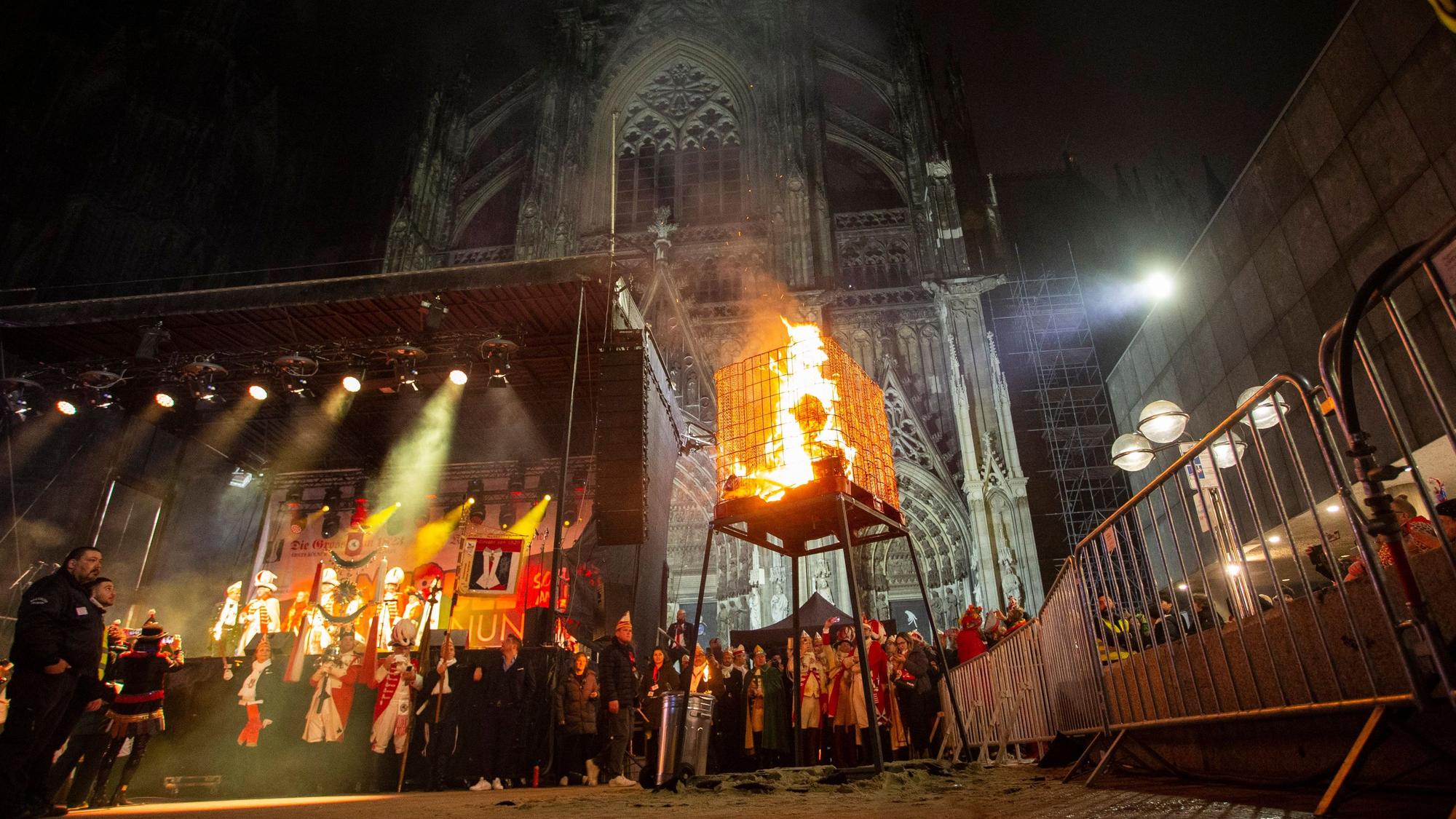 Vor dem angestrahlten Dom brennt der Nubbel in einem Käfig.