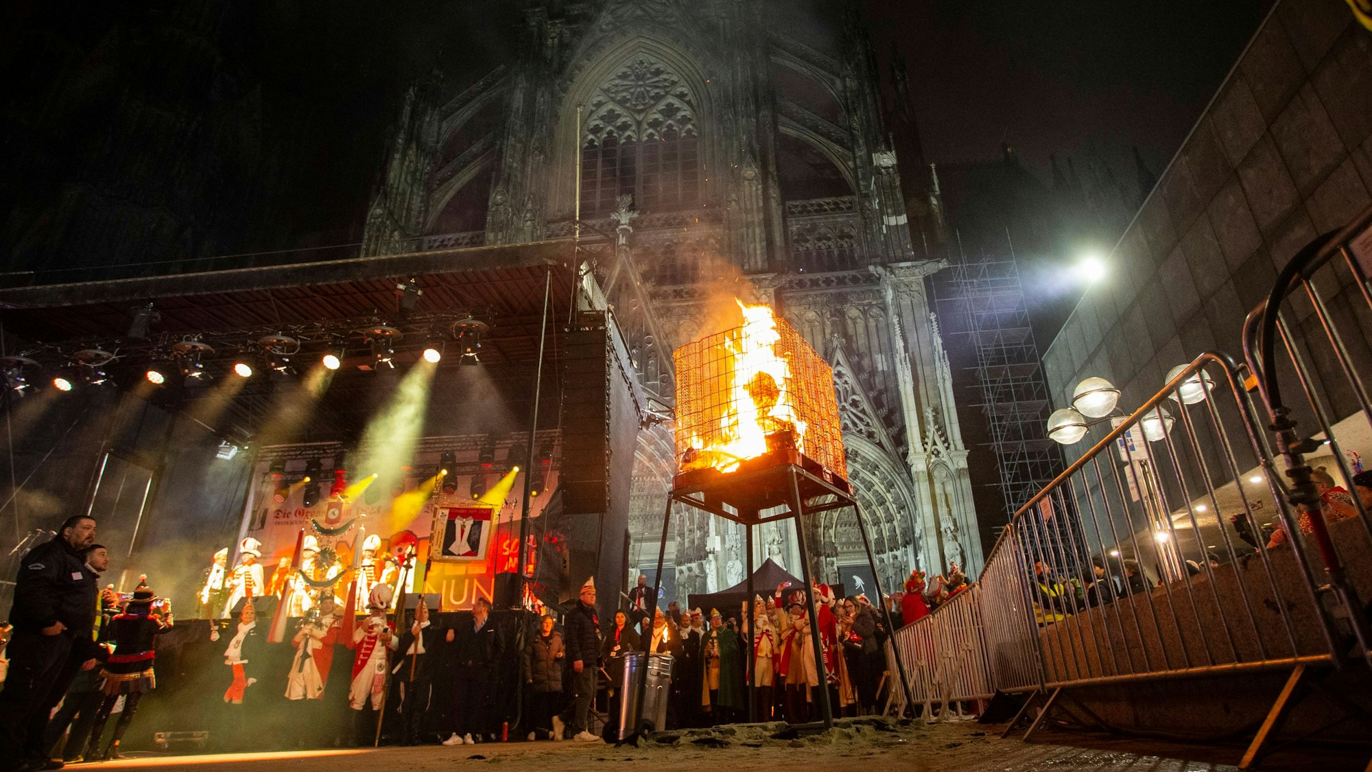 Vor dem angestrahlten Dom brennt der Nubbel in einem Käfig.