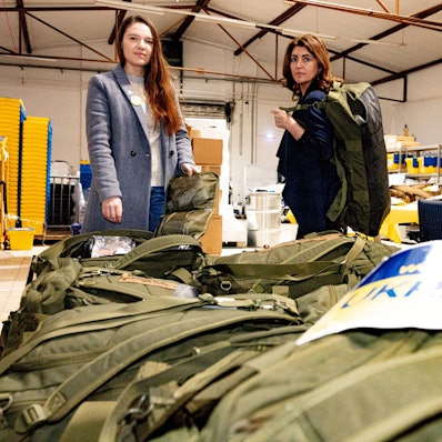 Julia Chenusha (l.) und Linda Mai vom Blau-Gelben Kreuz hinter den Rettungsrucksäcken für die Feldärzte im Lager in der Marktstraße in der Südstadt.