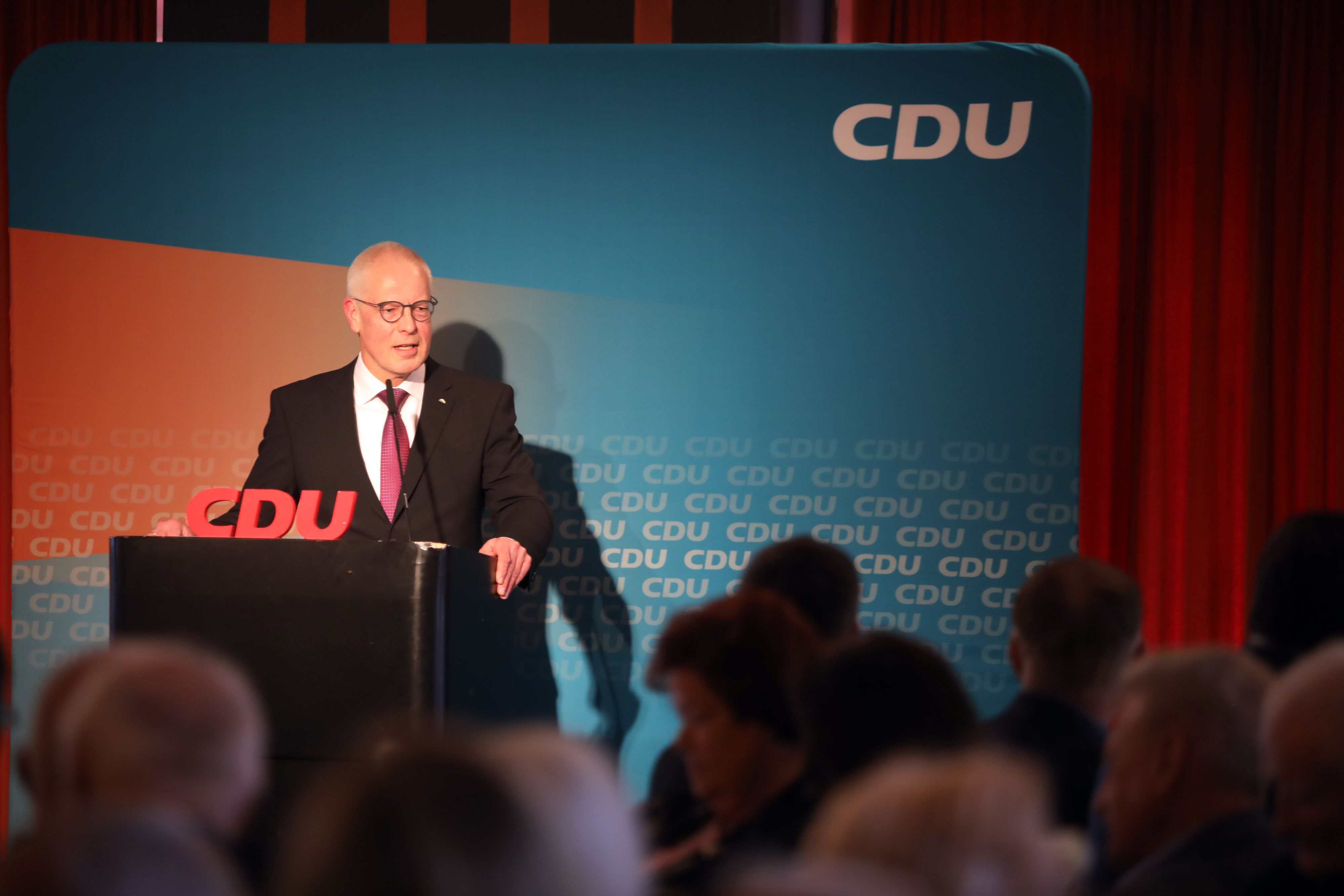 Der CDU-Kreisvorsitzender Dr. Hermann-Josef Tebroke steht bei einer Versammlung an einem Rednerpult vor einer Wand mit CDU-Schriftzügen.