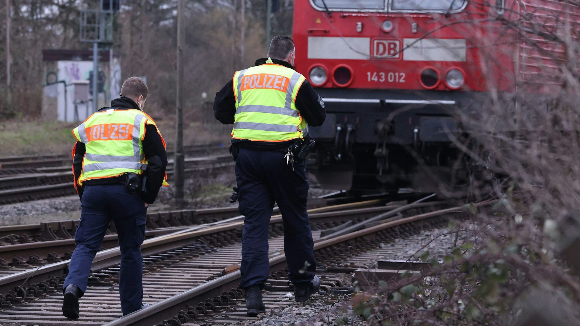 Zwei Polizisten gehen an einer Bahnstrecke entlang (Archivbild).