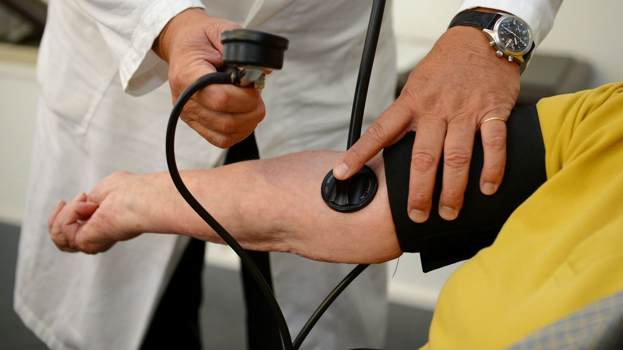 Ein Hausarzt misst den Blutdruck.