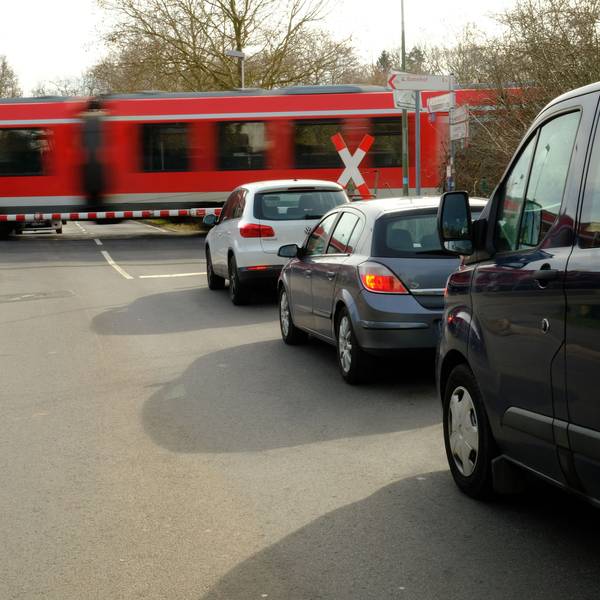 Vor dem Bahnübergang in Satzvey warten mehrere Autos, während ein Zug vorbeifährt.