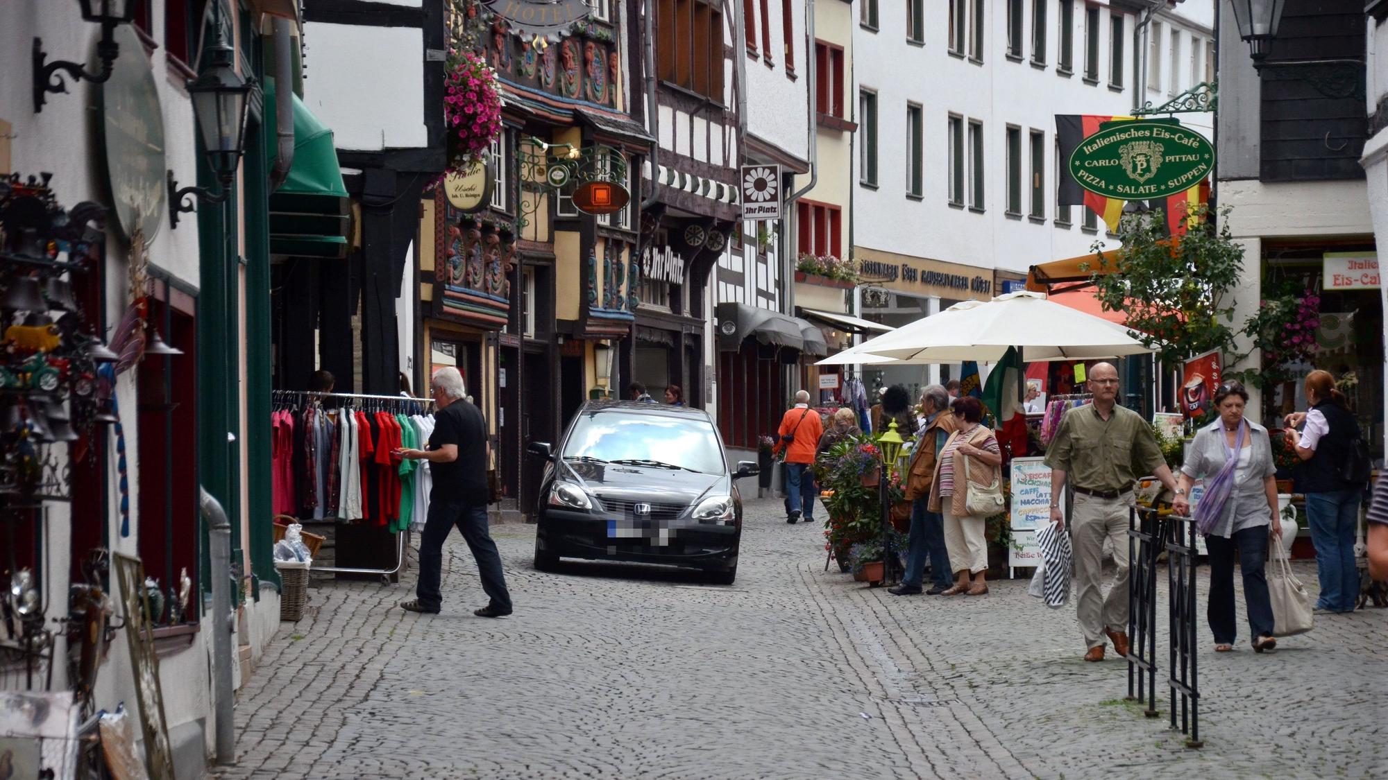 Ein Auto fährt im Jahr 2012 über die Orchheimer Straße in Bad Münstereifel, auf der auch Passanten schlendern.