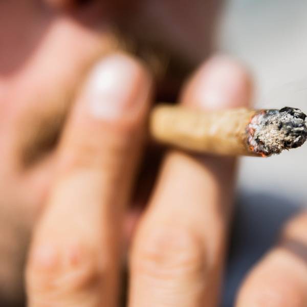 Ein Mann raucht einen Joint.