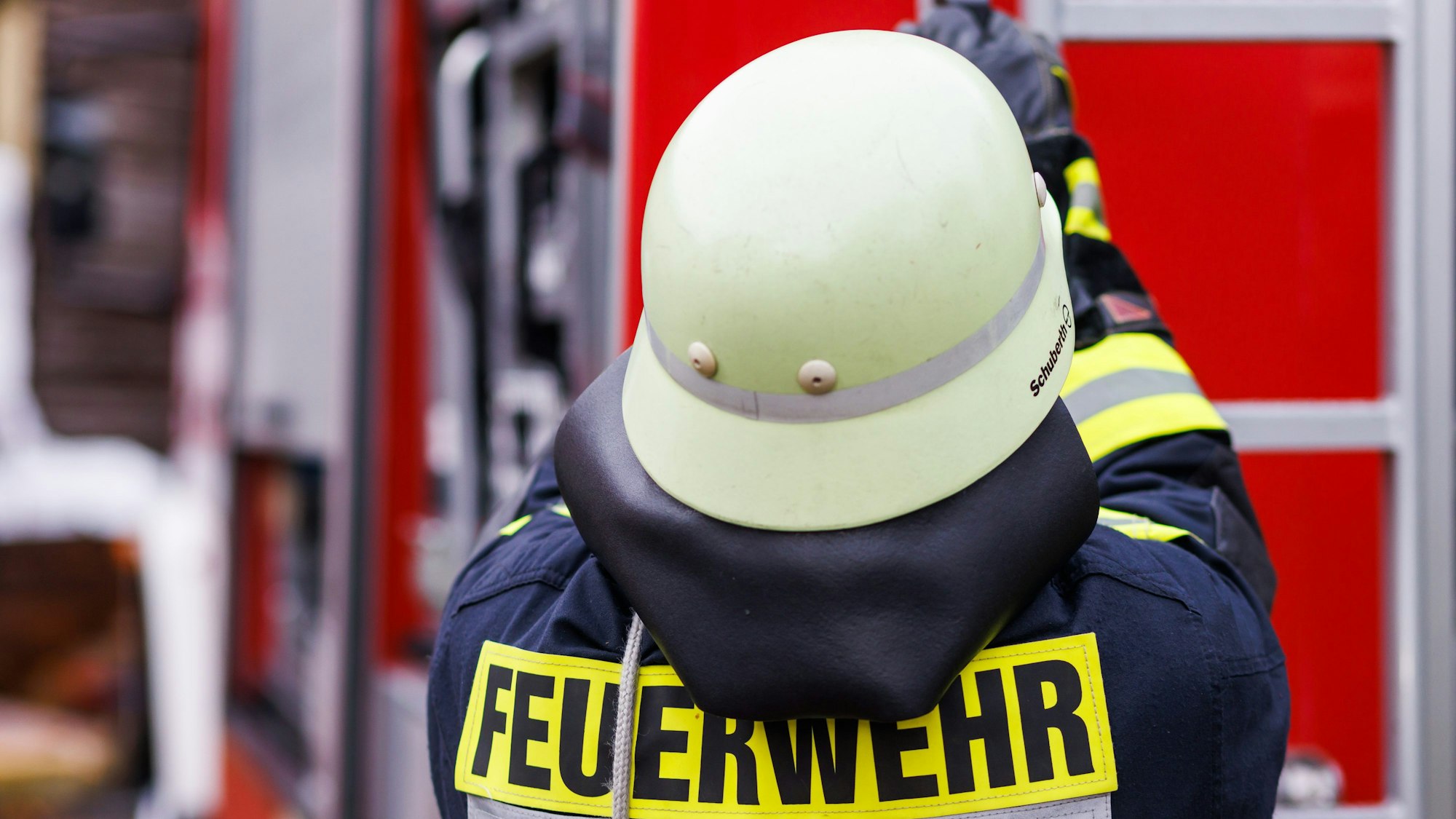 Ein Feuerwehrmann steht vor einem Feuerwehrauto.