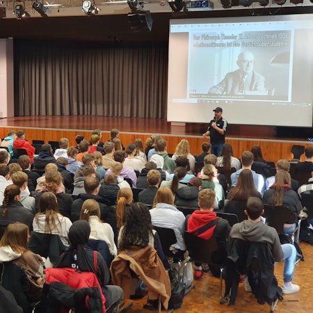 Ben Salomo steht in der Aula vor der Schülerschaft.